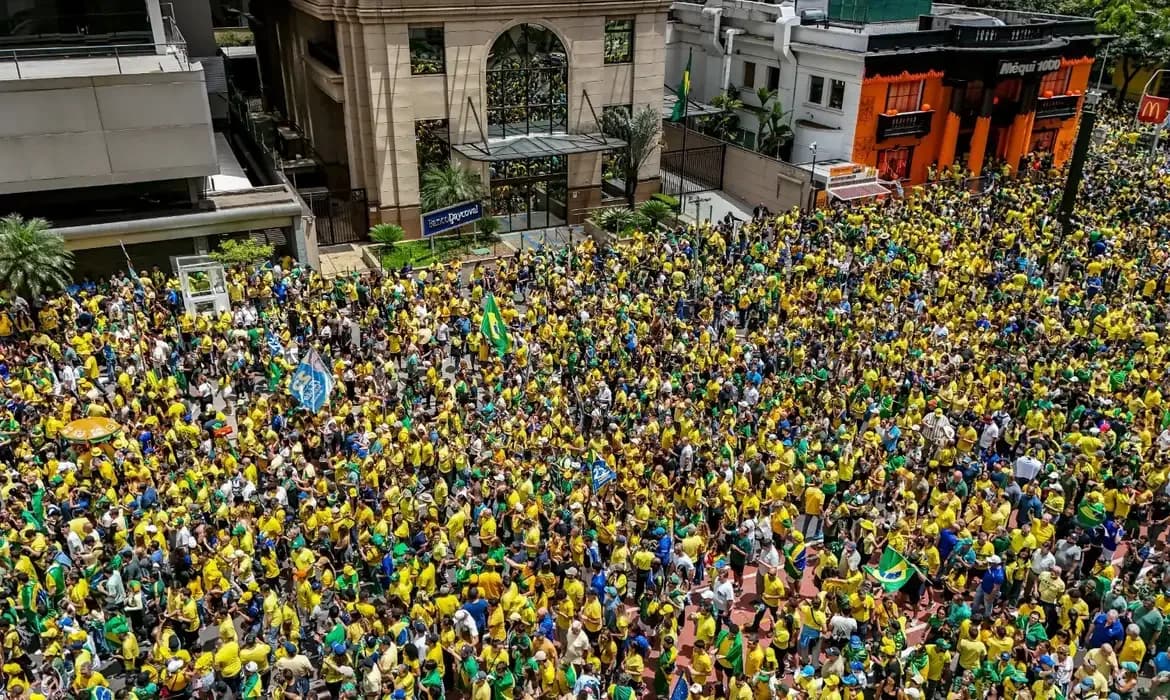 Vista do alto da Avenida Paulista tomada por uma multidão vestida de verde e amarelo, com bandeiras do Brasil entre os manifestantes